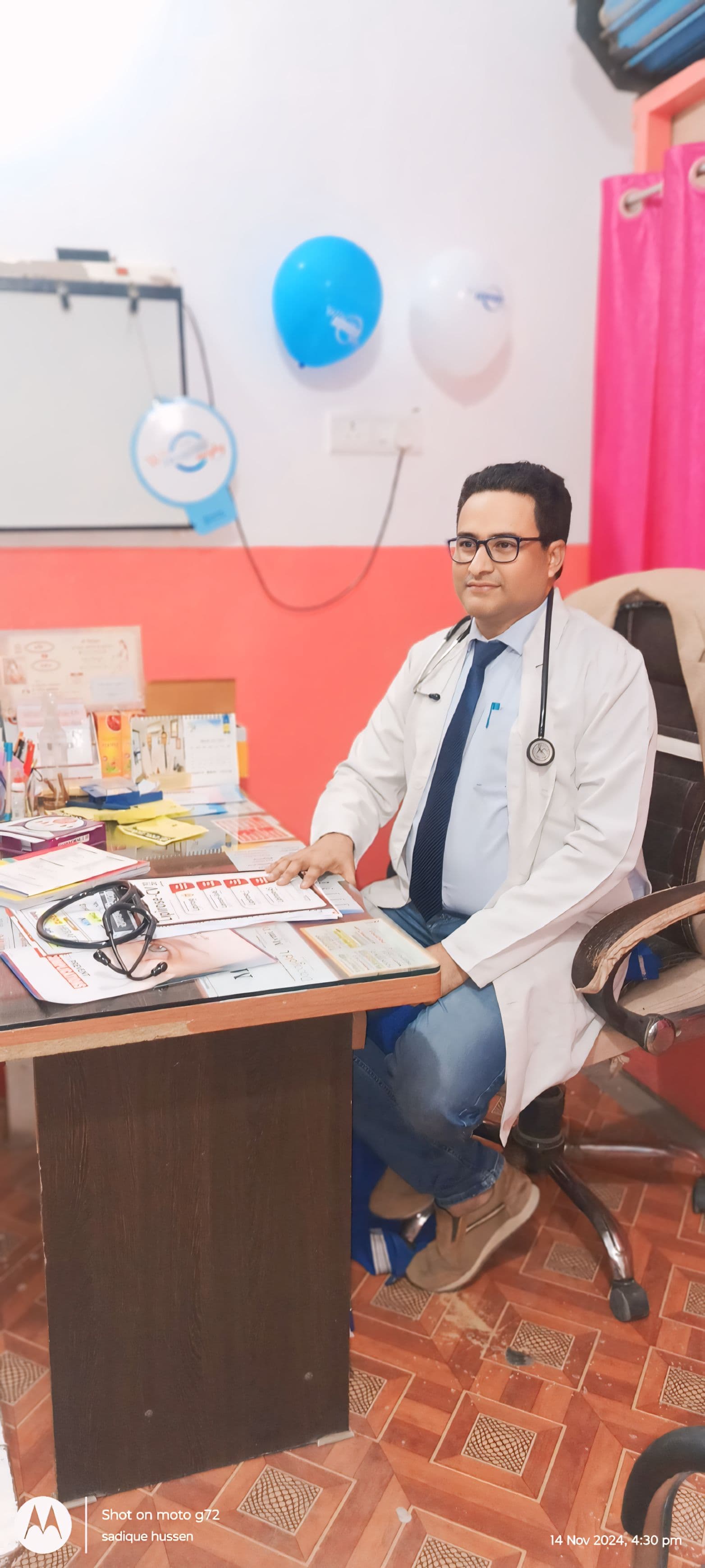 Dr. S. Hussain, physician and diabetologist in Siwan, at his clinic consultation desk reviewing patient records