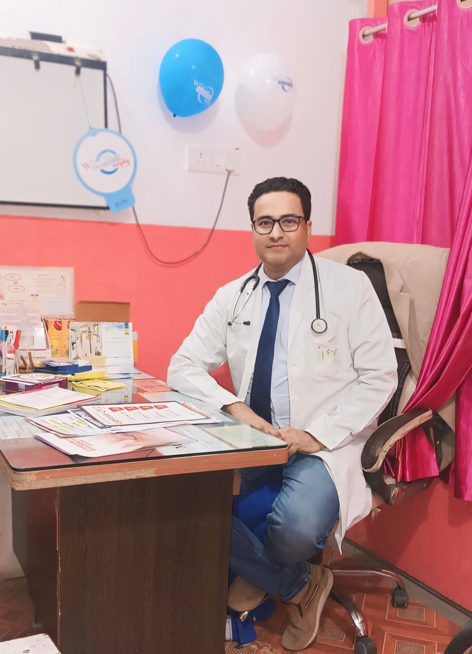 Interior of Dr. S. Hussain's Siwan clinic consultation room with doctor seated at patient desk